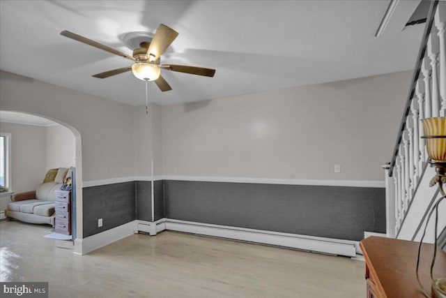 empty room with ceiling fan and a baseboard heating unit