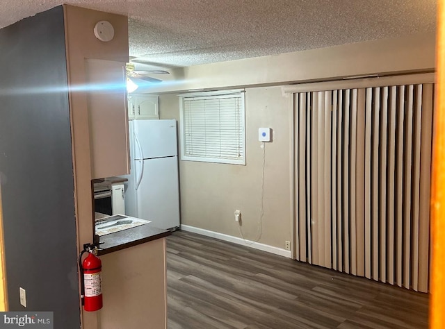 kitchen with a textured ceiling, white refrigerator, dark hardwood / wood-style floors, and ceiling fan