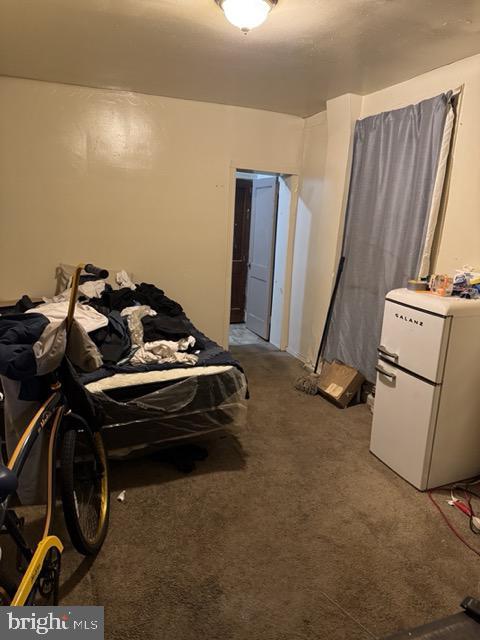 bedroom with carpet and white fridge