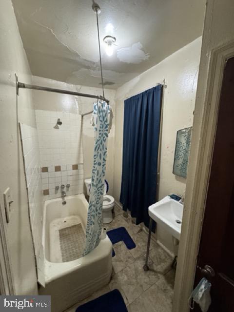 bathroom featuring shower / bath combo and toilet