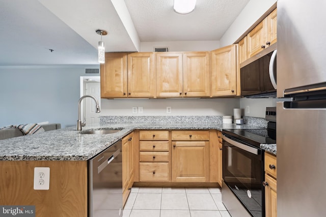 kitchen featuring kitchen peninsula, appliances with stainless steel finishes, light stone counters, sink, and pendant lighting