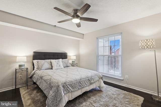 bedroom with ceiling fan, dark hardwood / wood-style flooring, and a textured ceiling