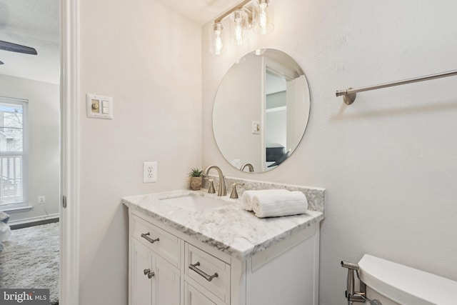 bathroom featuring vanity, toilet, a wealth of natural light, and ceiling fan