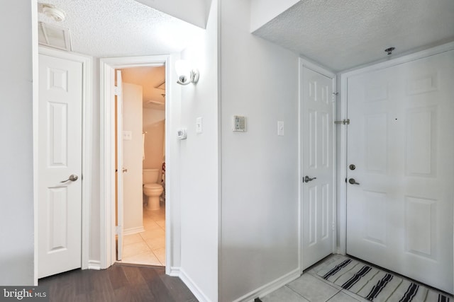 foyer featuring tile patterned flooring and a textured ceiling