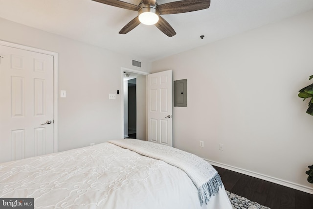 bedroom with electric panel, ceiling fan, and wood-type flooring