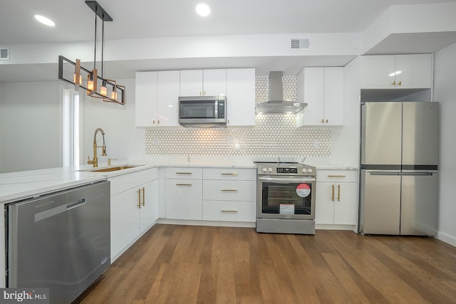 kitchen with white cabinetry, sink, wall chimney range hood, and appliances with stainless steel finishes