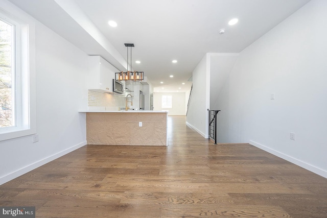 unfurnished living room with dark hardwood / wood-style floors, plenty of natural light, and sink