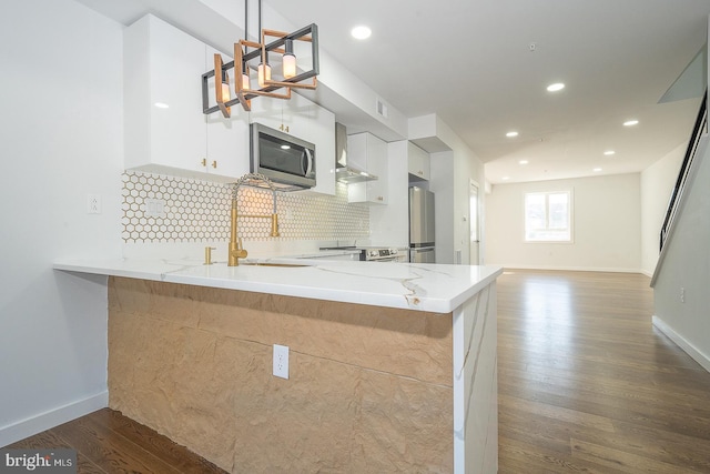 kitchen featuring dark hardwood / wood-style floors, white cabinetry, kitchen peninsula, and appliances with stainless steel finishes