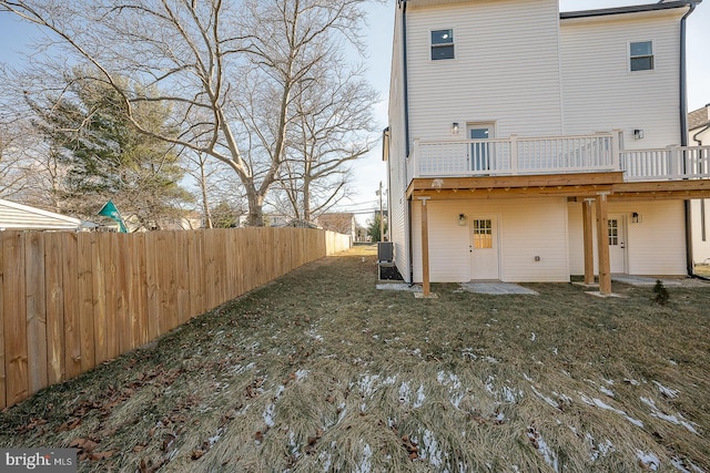 rear view of property with a yard, a wooden deck, and central air condition unit