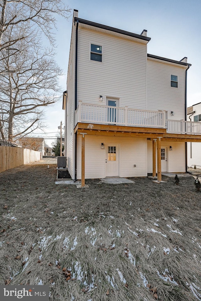 rear view of house featuring central AC and a wooden deck