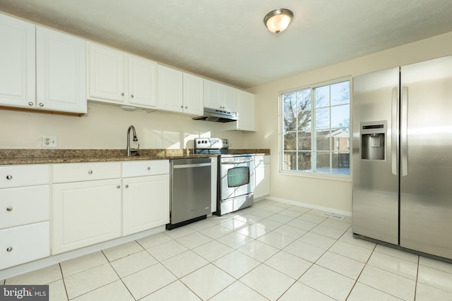 kitchen featuring sink, appliances with stainless steel finishes, light tile patterned floors, and white cabinetry