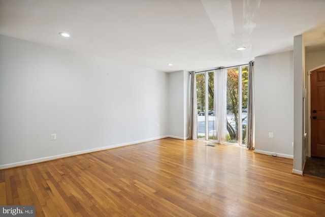 empty room with expansive windows and light wood-type flooring