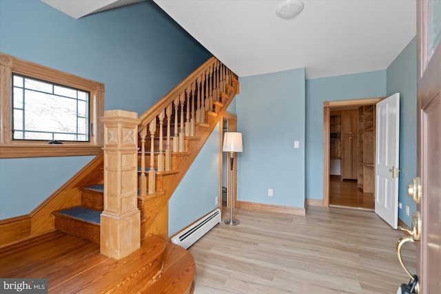 staircase with a baseboard radiator and hardwood / wood-style flooring