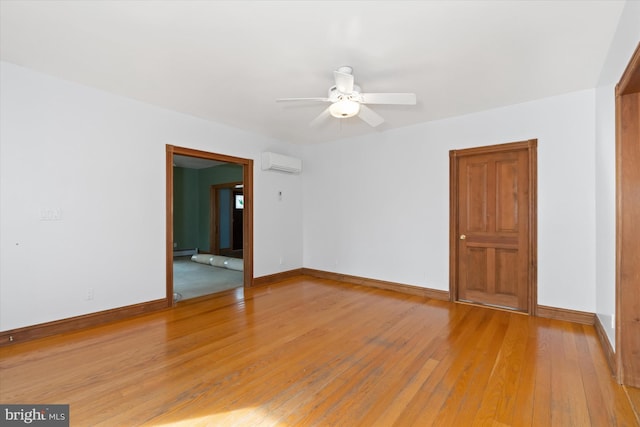 spare room with a wall mounted air conditioner, ceiling fan, hardwood / wood-style floors, and a baseboard heating unit