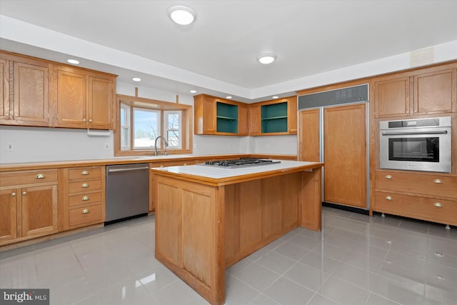 kitchen featuring sink, a kitchen island, light tile patterned floors, and appliances with stainless steel finishes