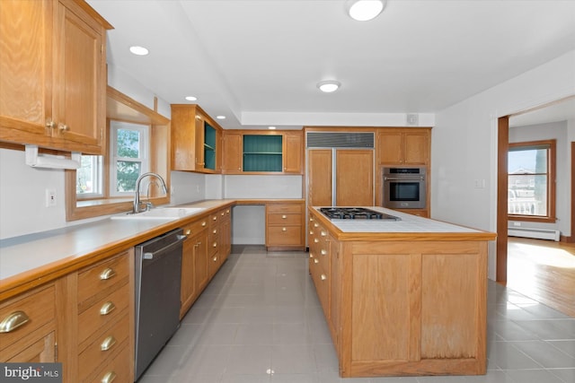 kitchen featuring stainless steel appliances, a baseboard heating unit, sink, light tile patterned floors, and a kitchen island