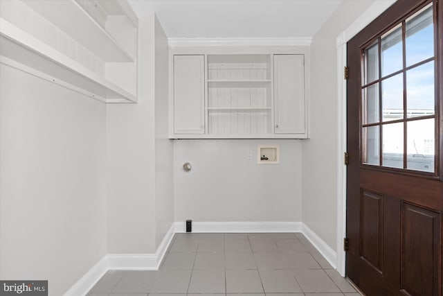 laundry area featuring cabinets, washer hookup, light tile patterned floors, and crown molding