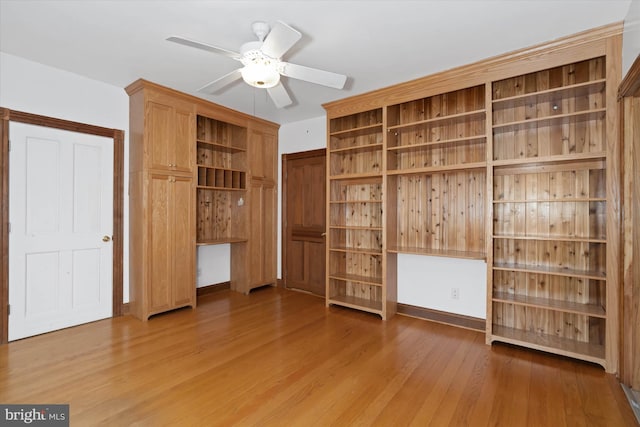 unfurnished bedroom with built in desk and wood-type flooring