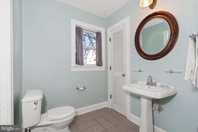 bathroom with toilet, tile patterned floors, and sink