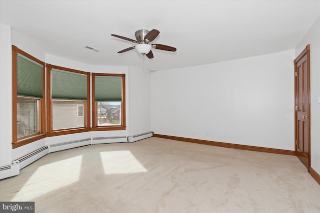 carpeted spare room featuring baseboard heating and ceiling fan