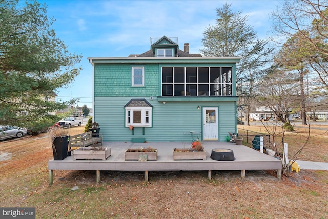 back of house with a sunroom and a deck