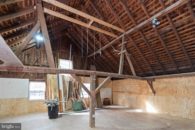 miscellaneous room featuring wooden walls and lofted ceiling