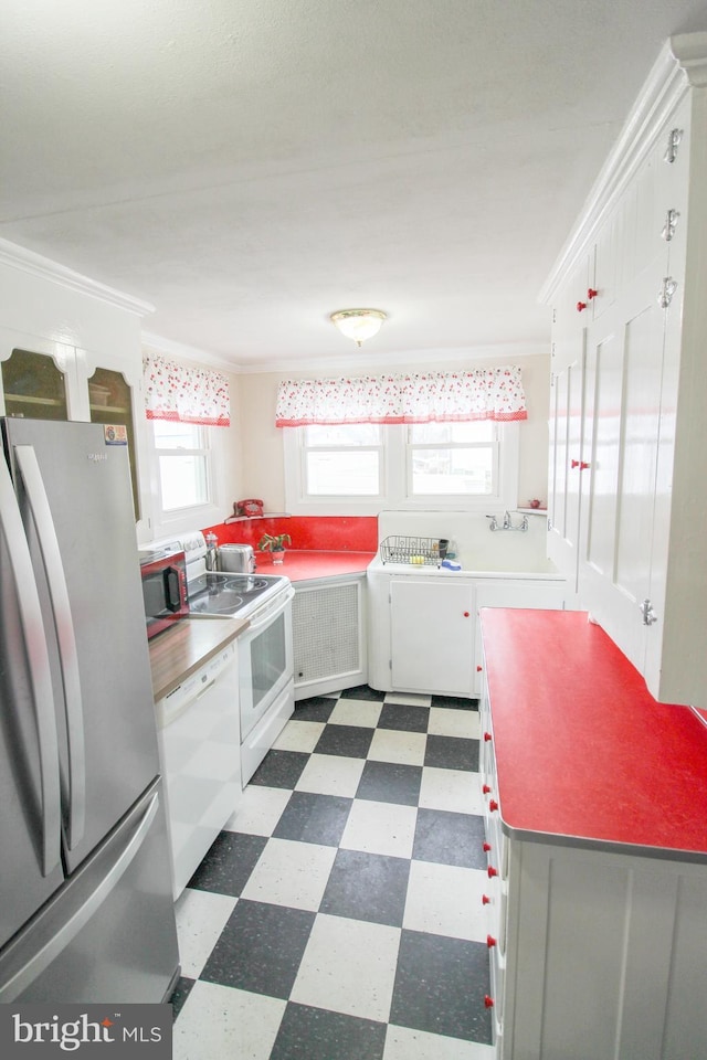 kitchen featuring washer / clothes dryer, white cabinets, white appliances, ornamental molding, and radiator