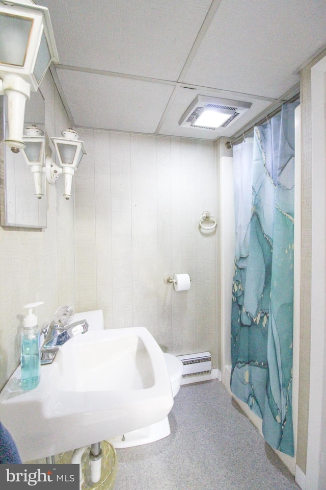 bathroom with sink, a shower with shower curtain, a baseboard radiator, and a drop ceiling