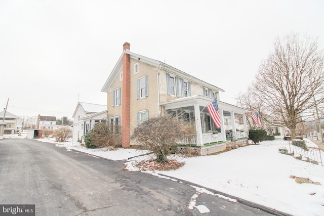 snow covered property featuring a porch