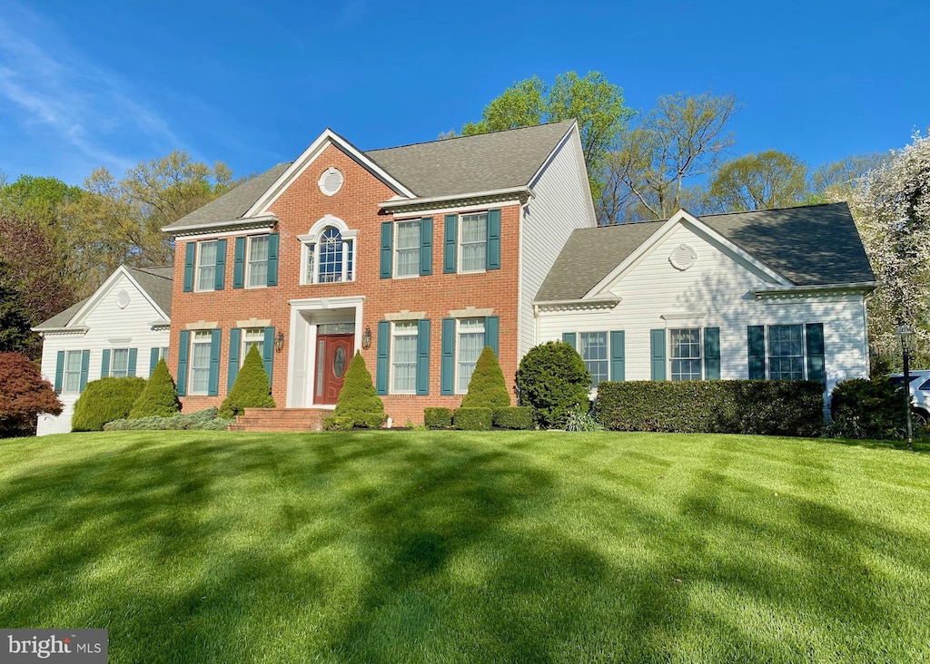 colonial inspired home with a front lawn