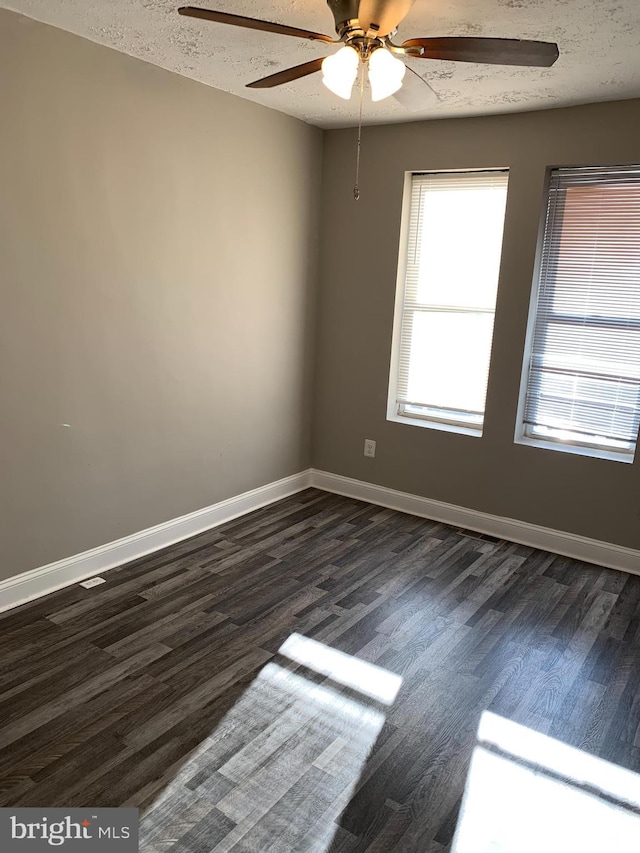 spare room featuring a textured ceiling, dark hardwood / wood-style floors, and ceiling fan