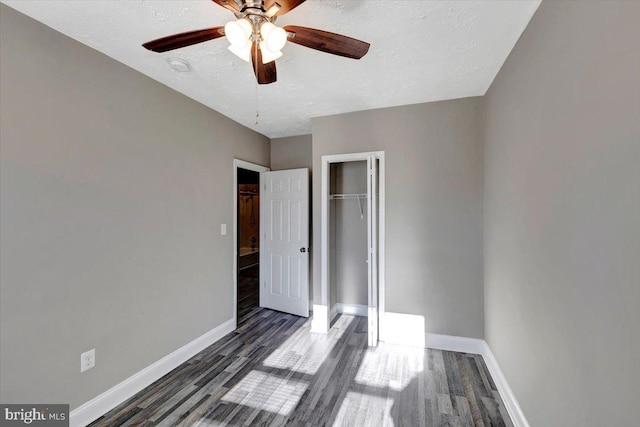 unfurnished bedroom with dark hardwood / wood-style flooring, ceiling fan, a closet, and a textured ceiling