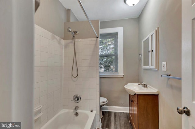 full bathroom with hardwood / wood-style floors, vanity, toilet, and tiled shower / bath