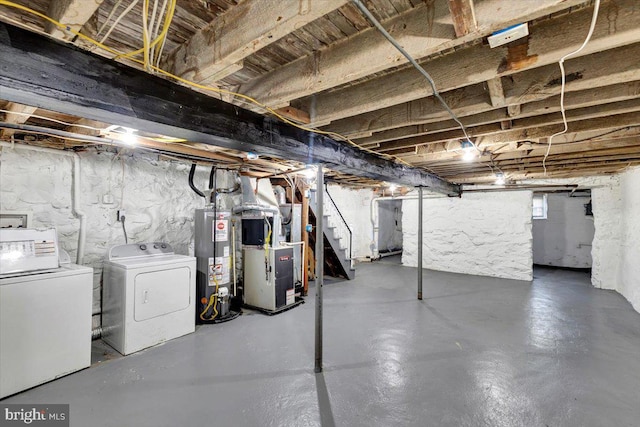 basement featuring gas water heater, independent washer and dryer, and heating unit