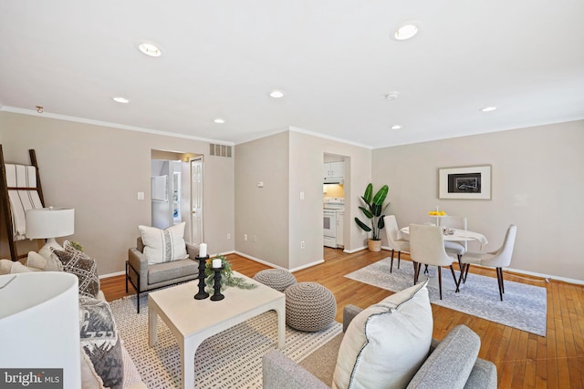 living room with light wood-type flooring and crown molding