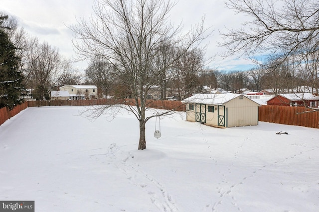 yard covered in snow with a storage unit