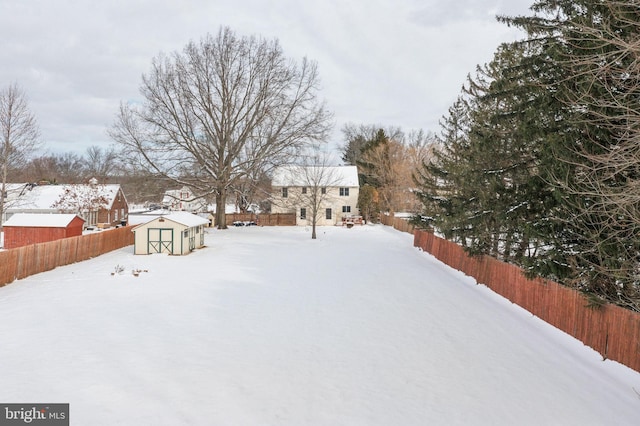 yard layered in snow with a storage unit