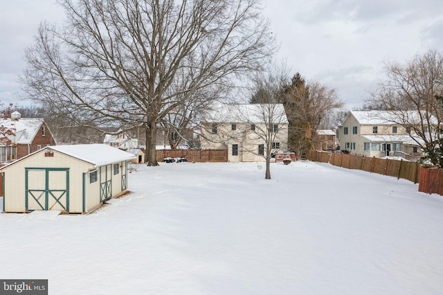 snowy yard with a storage shed