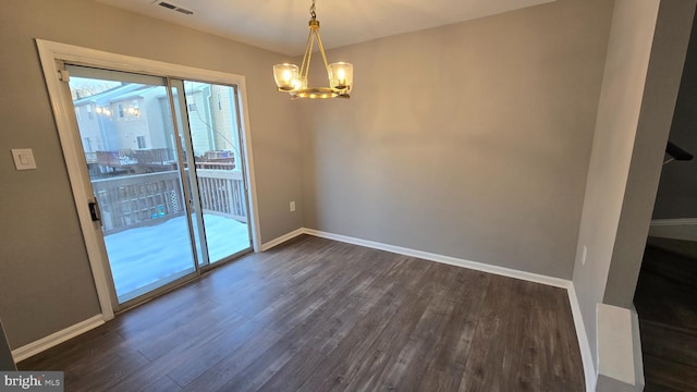 unfurnished dining area featuring a notable chandelier and dark hardwood / wood-style floors