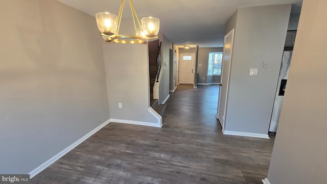 corridor featuring dark wood-type flooring and an inviting chandelier