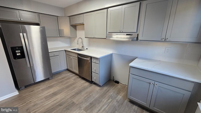 kitchen with light wood-type flooring, stainless steel appliances, gray cabinetry, and sink