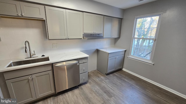 kitchen featuring dishwasher, sink, decorative backsplash, gray cabinets, and wood-type flooring