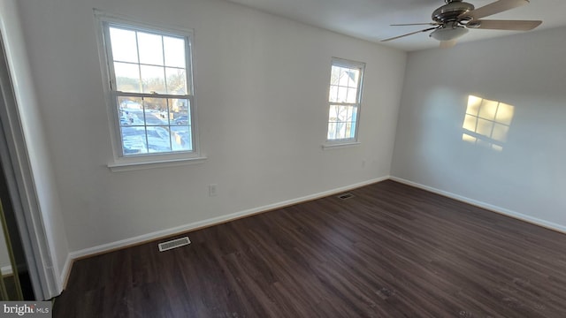 spare room featuring a wealth of natural light, dark wood-type flooring, and ceiling fan