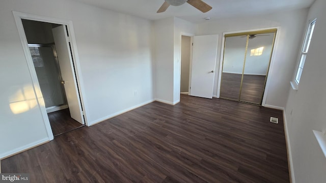 unfurnished bedroom with ceiling fan, a closet, and dark wood-type flooring