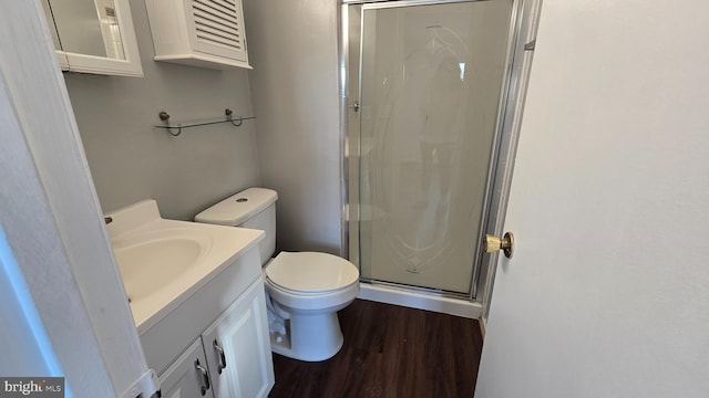 bathroom featuring toilet, vanity, wood-type flooring, and walk in shower