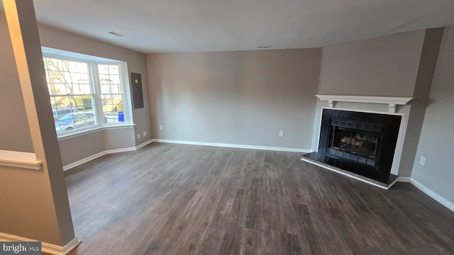 unfurnished living room with dark hardwood / wood-style flooring and electric panel