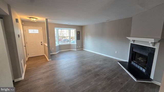 unfurnished living room with dark hardwood / wood-style floors and electric panel