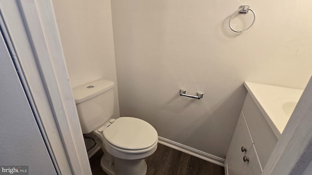 bathroom featuring vanity, hardwood / wood-style flooring, and toilet