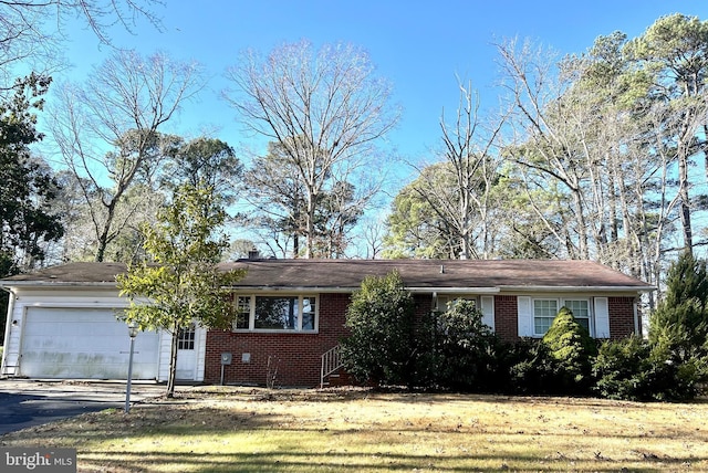 ranch-style home featuring a garage and a front yard