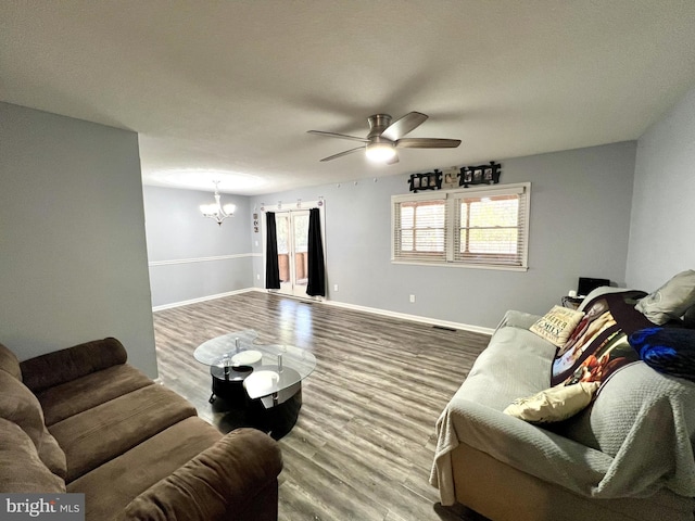 living room with hardwood / wood-style floors and ceiling fan with notable chandelier